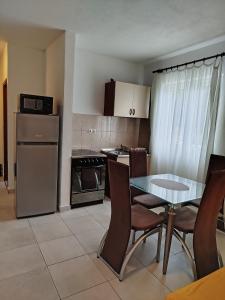 uma cozinha com uma mesa e cadeiras e um frigorífico em Apartmani Blazevic em Omiš