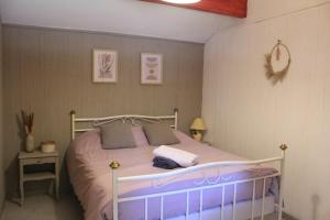 una camera da letto con letto e lenzuola e cuscini viola di Lou Pitchoun Cabanoun à Eygalières "2-3 Personnes" a Eygalières