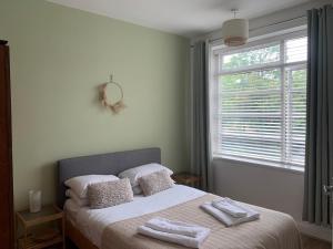 Linnet House - Relaxing - Leafy - Bright 2 Bedroom Apt tesisinde bir odada yatak veya yataklar