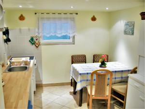 uma pequena cozinha com uma mesa e um lavatório em 2 bedrooms apartement with shared pool garden and wifi at Obernaundorf 7 km away from the beach em Obernaundorf