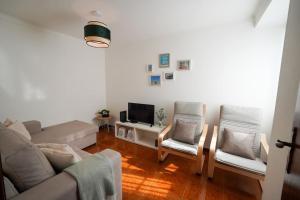 sala de estar con sofá y 2 sillas en Casa do Largo, en Nazaré
