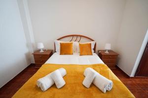 1 dormitorio con 1 cama con 2 toallas en Casa do Largo, en Nazaré