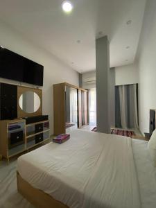 1 dormitorio con 1 cama blanca grande y TV en Jasmine Resort & Aqua park en Sharm El Sheikh