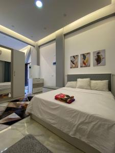 a bedroom with a large white bed and a television at Jasmine Resort & Aqua park in Sharm El Sheikh