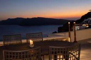 una vela sentada en una mesa con vistas al océano en Magic View Canava, en Oia