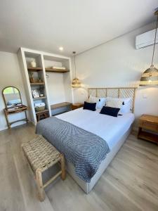 ein Schlafzimmer mit einem großen weißen Bett und einer Bank in der Unterkunft Casas de Campo - Vale da Terça in Vermelho