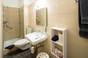 uma casa de banho com um lavatório, um WC e um chuveiro em Hotel Garni dei fiori em Ascona mais 37 fotografias