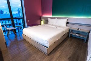 a large bed in a room with a large window at Yello Hotel Cebu powered by Cocotel in Cebu City