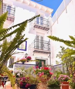 un edificio blanco con macetas y balcones en Hostal Enriqueta, en Marbella