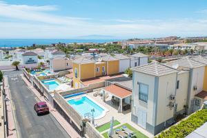 un apartamento con 2 piscinas y una calle con edificios en Cozy villa in Madroñal de Fañabe with large private pool, en Adeje