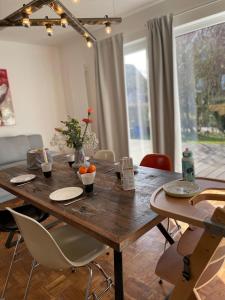 a wooden table in a living room with chairs and a dining room at Casa Marcu Wohnung 2 EG in Landkirchen