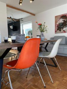 a dining room table with two orange chairs at Casa Marcu Wohnung 2 EG in Landkirchen