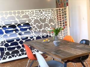a dining room table with orange chairs and a wall at Casa Marcu Wohnung 2 EG in Landkirchen