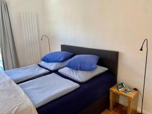 a bed with blue sheets and pillows on it at Casa Marcu Wohnung 2 EG in Landkirchen