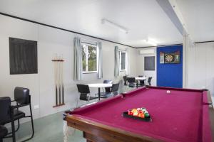 a red pool table in a room with chairs at Discovery Parks - Mt Isa in Mount Isa