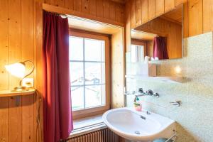 La salle de bains est pourvue d'un lavabo et d'une fenêtre. dans l'établissement Gasthaus Edelweiss, à Vals