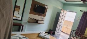 um quarto com uma mesa e uma televisão na parede em sri Murugan beach paradise hotel em Mahabalipuram