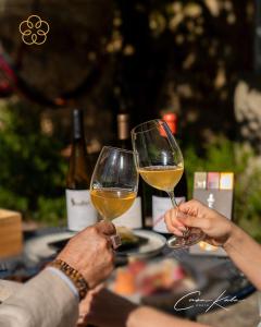 dos personas están sosteniendo copas de vino blanco en Casa Kala, en Oporto