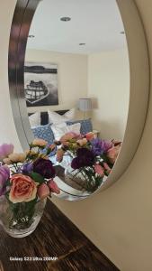 a mirror with two vases of flowers on a table at Bala Holiday Suites in Bala