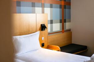 1 dormitorio con 1 cama y 1 silla en una habitación en easyHotel Nice Palais des Congrès – Old Town en Niza