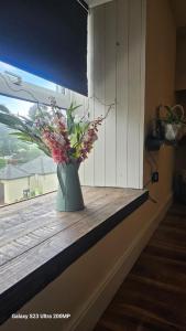 un jarrón de flores sentado en un alféizar de la ventana en Bala Holiday Suites en Bala