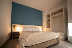 1 dormitorio con 1 cama grande y pared azul en Villaggio San Matteo Resort, en Mattinata