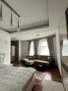 1 dormitorio con 1 cama y sala de estar con sofá en Diamond Hotel & Restaurant, en Ulcinj