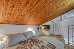 una camera con letto e soffitto in legno di Apartments Marija 1000 a Rabac