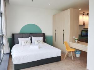 a bedroom with a bed and a yellow chair at The Avalon - Bangsar Trade Centre in Kuala Lumpur