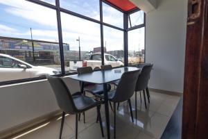 a table and chairs in a room with windows at Safi Classic 3 bedroom Apartment 4 in East London