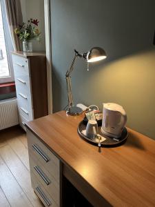 un escritorio con una lámpara y una taza. en Hillhouse Blackhall en Edimburgo