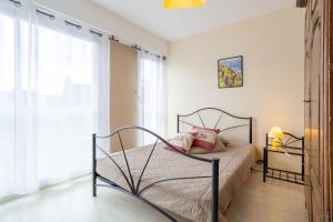 een slaapkamer met een bed met roze kussens erop bij Appartement Le Croas Men in Douarnenez