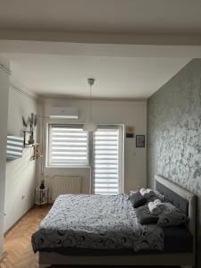 a bedroom with a bed and a large window at Loli apartman in Kraljevo