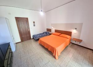 ein Schlafzimmer mit einem orangenen Bett in einem Zimmer in der Unterkunft ROSSO - PROPPRO SRL - MILAZZO ISOLE EOLIEe in Milazzo