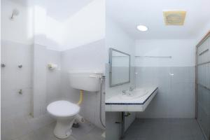 a bathroom with a toilet and a sink and a mirror at OYO 90089 N H Inn in Rumah Imba