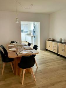 a dining room table with chairs and a kitchen at Belle maison proche mer Sangatte Blériot-plage in Sangatte