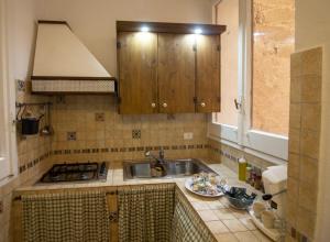uma cozinha com um lavatório e um prato de comida no balcão em Attracco Apartment em Trapani
