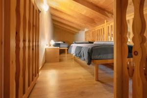 a bedroom with two beds and wooden walls at Baita Florin in Livigno