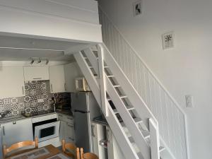a kitchen with a white staircase in a kitchen at Natha de la Plage 2000 in Brétignolles-sur-Mer +6 photos