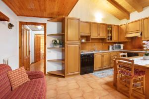 a large kitchen with wooden cabinets and a table at Baita Florin in Livigno +11 photos