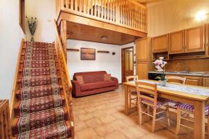a kitchen and living room with a staircase and a couch at Baita Florin in Livigno