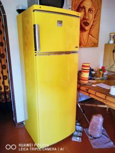 a yellow refrigerator in a room with a table at 2 bedrooms apartement at Porto Recanati 200 m away from the beach with furnished terrace in Porto Recanati