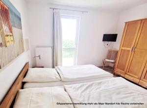 two beds in a bedroom with a window at Apartmentvermittlung Mehr als Meer - Objekte 42 & 51 in Niendorf