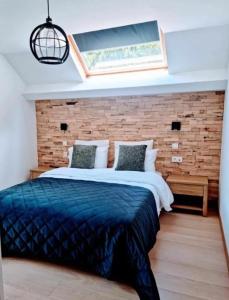 a bedroom with a large bed with a brick wall at Hotel L'ermitage in Houffalize