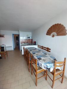 ein Esszimmer und eine Küche mit einem Tisch und Stühlen in der Unterkunft front de mer 2 chambres parking quartier corniche in Sète