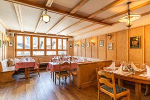 um restaurante com mesas e cadeiras num quarto em Gasthaus Edelweiss em Vals