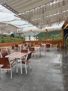 patio ze stołami, krzesłami i żyrandolami w obiekcie Ilio Boutique Hotel w mieście Ksamil