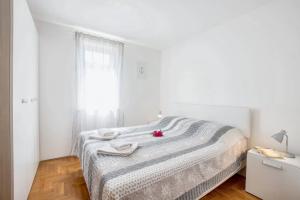 a white bedroom with a bed with towels on it at 2 bedrooms apartement with furnished balcony and wifi at Basanija 2 km away from the beach in Bašanija