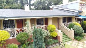 Casa pequeña con porche y escalera en Mayas Suites en Nyeri