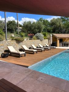 une terrasse avec des chaises longues à côté d'une piscine dans l'établissement Côté vignes cassis, à Cassis